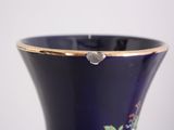 a blue vase with a gold rim sitting on a table