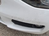 a close up of a car ' s front bumper with dirt on it