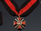 a red and black ribbon with a gold cross on it