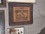 many pictures on the wall of a room with a chair