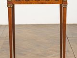 an antique wooden table with a marble top on a herringle floor