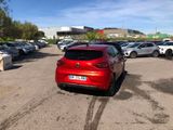 the red car is parked in the parking lot near other cars