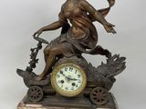 a bronze statue of a woman sitting on top of a clock