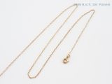 a close up of a gold necklace with a chain on a white background