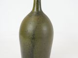 a green vase that is sitting on a white surface