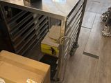 une cuisine avec une table en inox et des cartons posés par terre