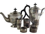 a silver tea set with cups and a teapot