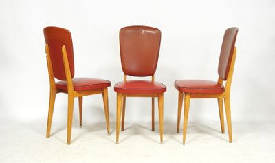 trois fauteuils en cuir rouge aux pieds en bois, adossés à un mur blanc