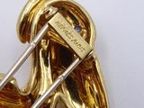 a gold brooch with a pin in the shape of a dog