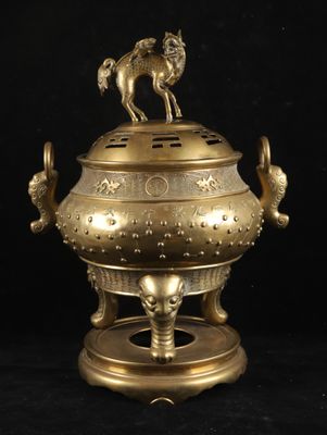 an antique brass incense burner with a horse on top