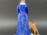 figurine of a woman in a blue dress with a cat on a base