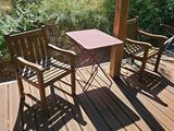 deux chaises en bois et une table sur une terrasse en bois