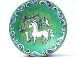 a green plate with a picture of a white horse on it