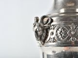 a silver vase sitting on top of a table