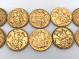 un groupe de six souverains d'or posés sur une surface blanche