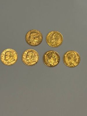 six souverains d'or alignés sur une surface blanche