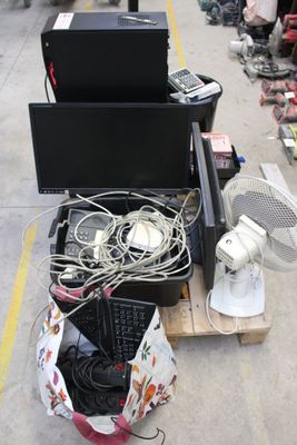 a pile of electronics sitting on the ground next to a fan