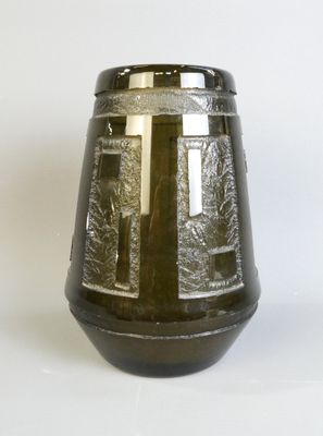 un vase noir orné d'une croix, posé sur une table