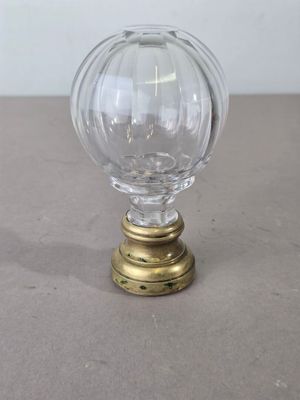 a glass ball on a brass base on a table
