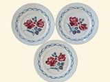 trois assiettes blanches ornées de fleurs rouges sur un fond blanc