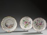 trois assiettes ornées d'oiseaux et de fleurs, posées sur une table