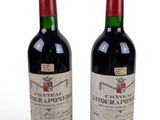 two bottles of wine sitting next to each other on a white surface