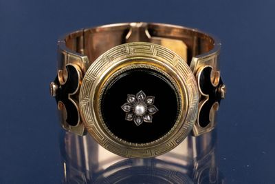 un bracelet en or orné d'une pierre noire au centre