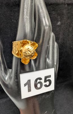 une bague en or sur laquelle est représenté un lion assis sur une main