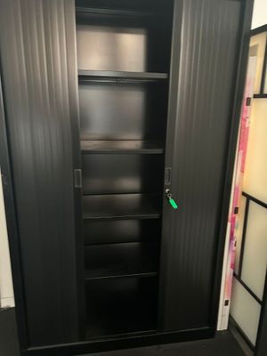 une photo d'une armoire noire sur laquelle est accrochée une étiquette verte