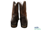 pair of brown cowboy boots on a white background with the words adn le mois