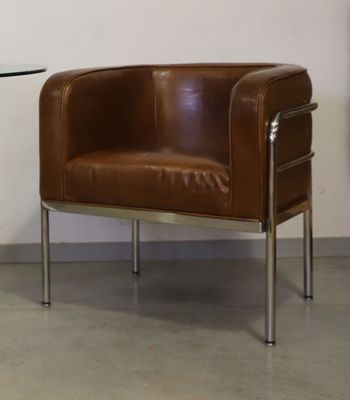 un fauteuil en cuir marron et une table en verre dans une pièce