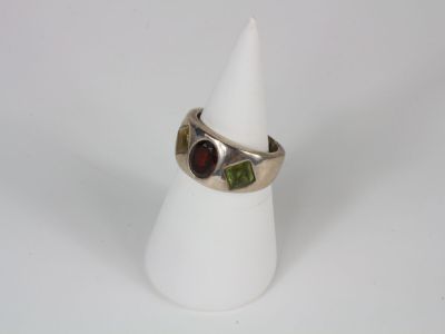 silver ring with garnetts and garnetts on it on a white cone
