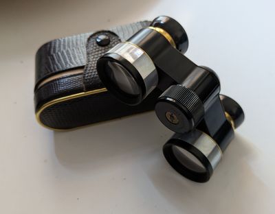 a pair of binoculars sitting on a table next to a case