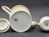 two cups and a saucer on a table with a gray background