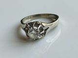 une image d'une bague en diamant sur une surface blanche