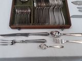 un plateau avec des couverts posé sur une table, comprenant un couteau, une fourchette, une cuillère et un repose-cuillère