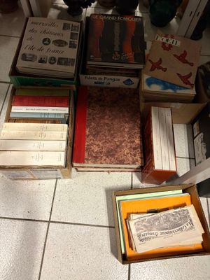 a pile of books sitting on the floor next to a pile of other books