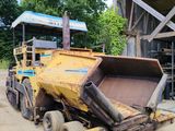 un camion-benne garé devant un immeuble