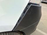 a close up of the front bumper of a white car