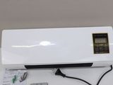 an air conditioner sitting on top of a table next to a remote control