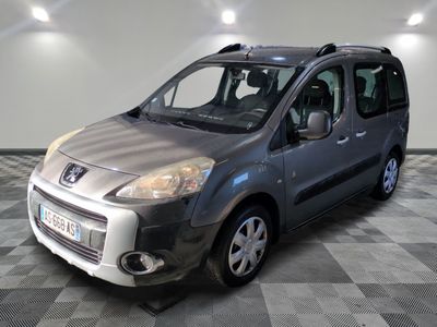 une photo d'une petite camionnette argentée garée dans un garage