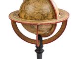 un vieux globe terrestre posé sur un socle, sur fond blanc