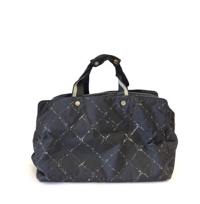 the large black handbag is sitting on a white surface