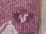 a pink sweater with a bear on it on a table