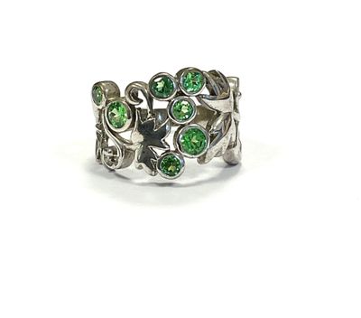 a close up of a ring with green stones on it