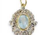 a close up of a pendant with a blue stone surrounded by diamonds