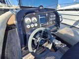 a steering wheel and dashboard of a boat on the water
