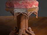 une table en bois sur laquelle est posé un tabouret rembourré rouge