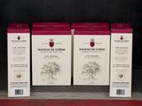 trois cartons de vin posés sur une étagère devant un mur noir