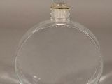 a clear glass bottle with a gold top on a table